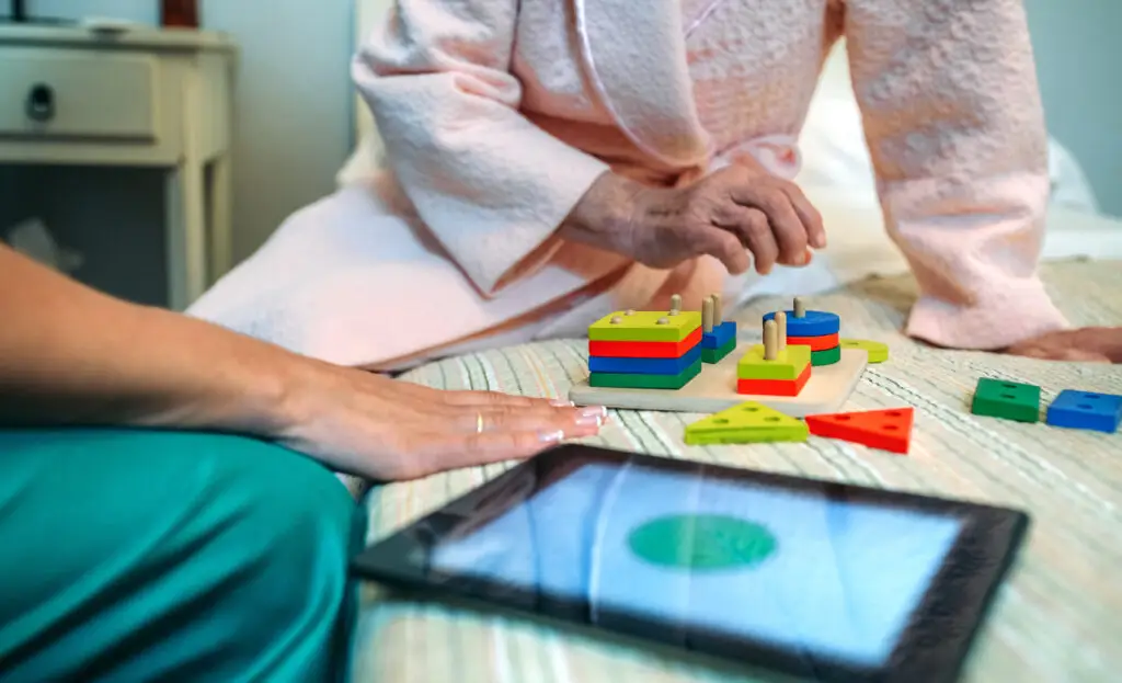 Female doctor showing geometric shapes to elderly patient - The Williamsport Home